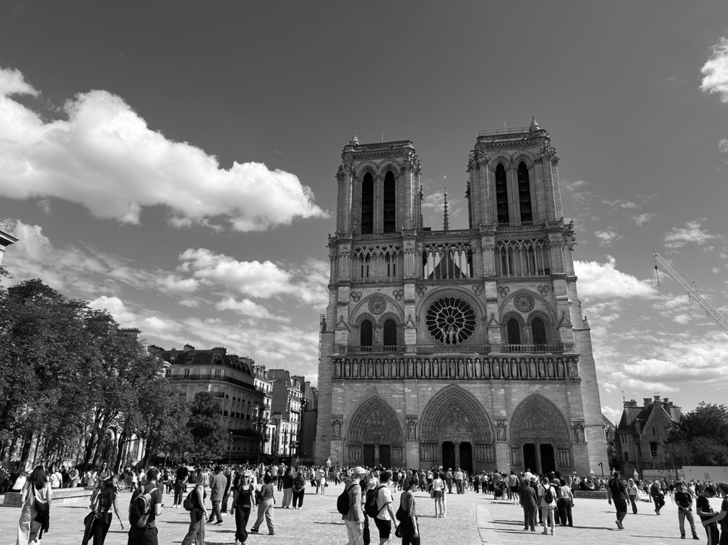 Black and white photo of Notre-Dame cathedral and the crowd in front of it